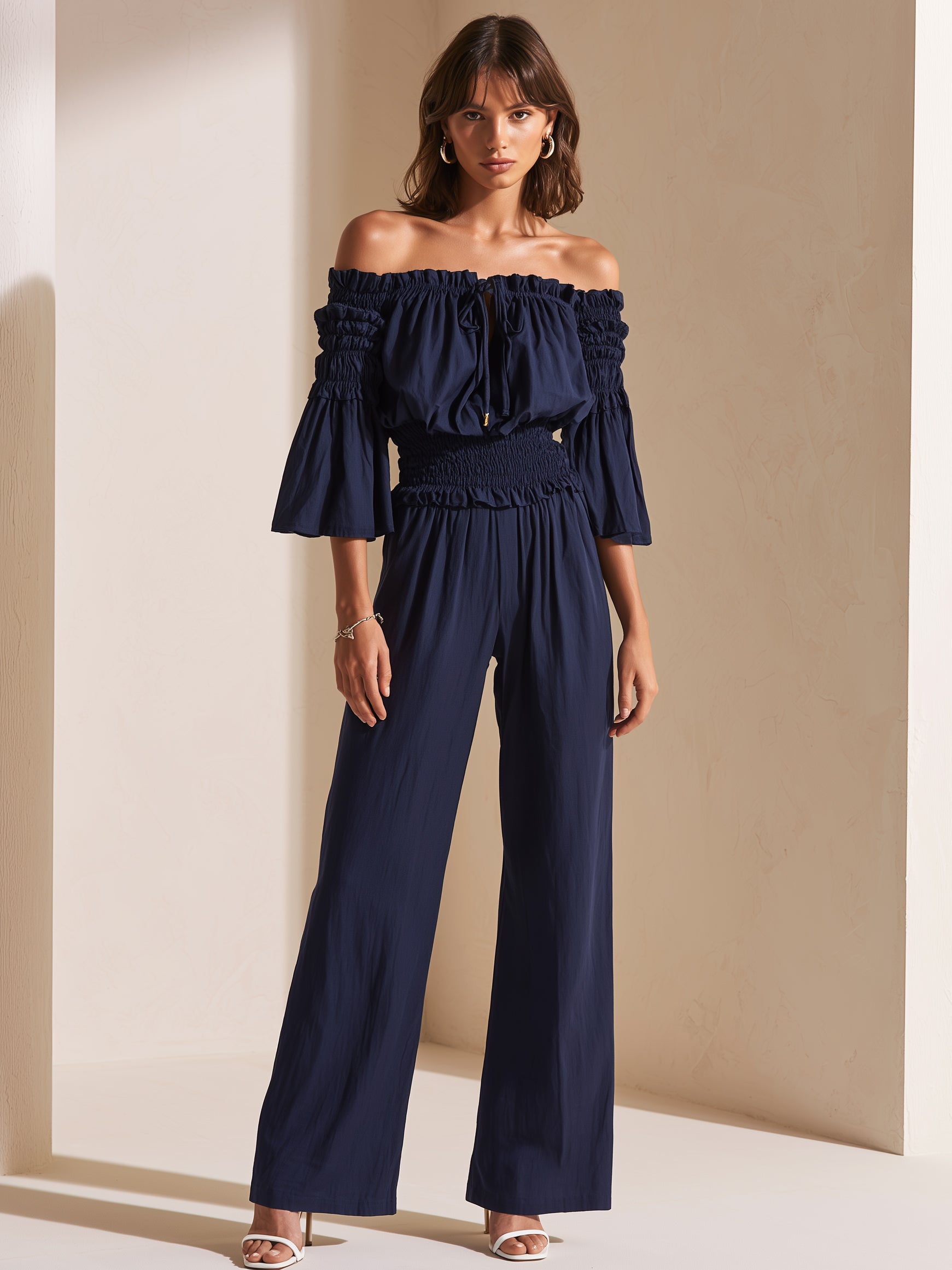Elegant Dark Blue Off-shoulder Jumpsuit With A Drawstring Waist And Smocked Detailing.