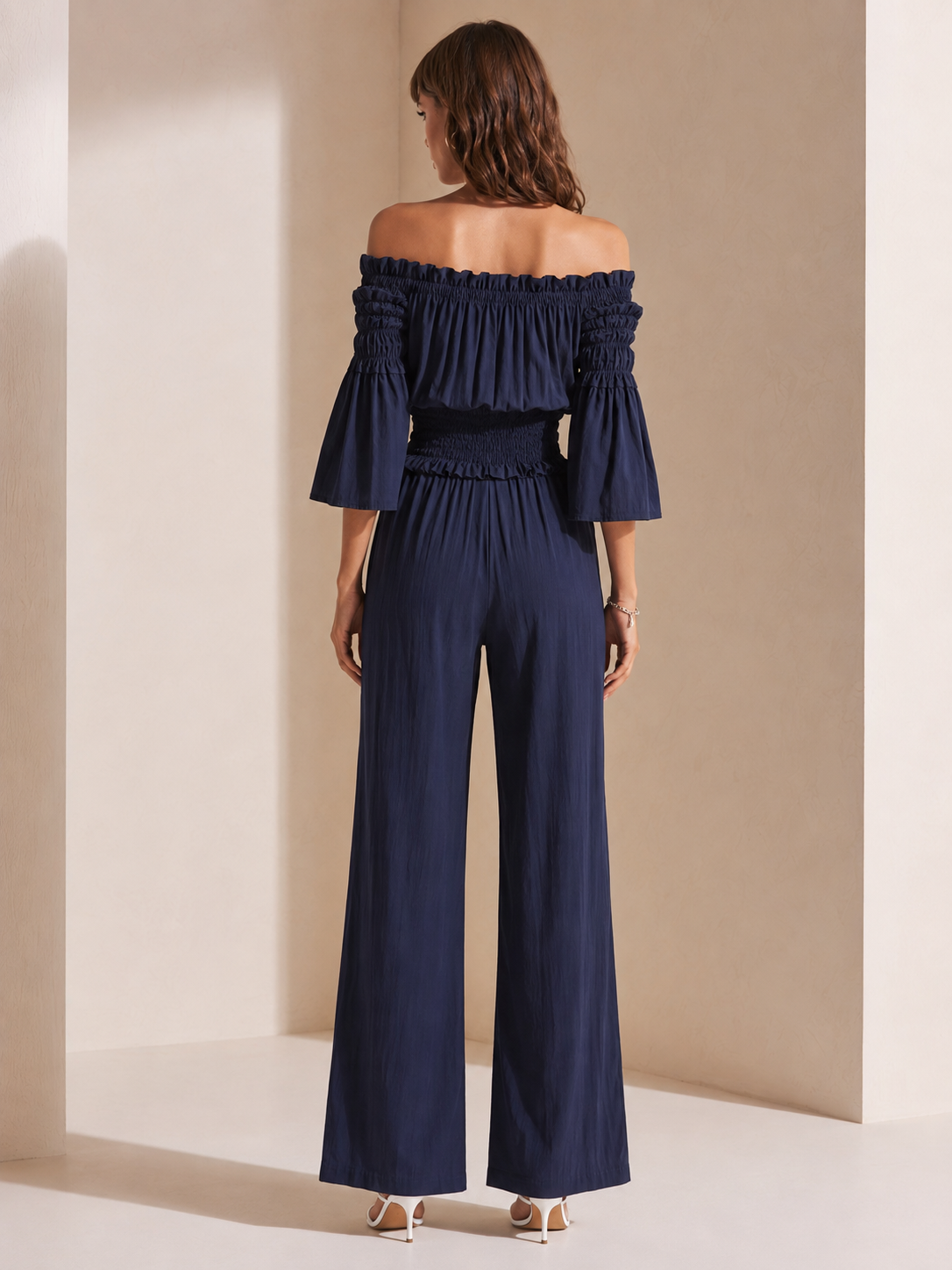Elegant Dark Blue Off-shoulder Jumpsuit With A Drawstring Waist And Smocked Detailing.