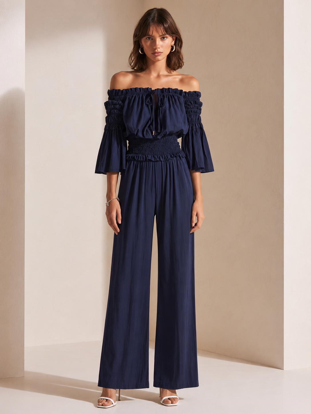 Elegant Dark Blue Off-shoulder Jumpsuit With A Drawstring Waist And Smocked Detailing.