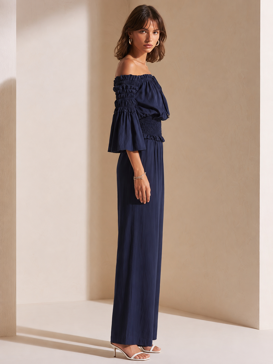 Elegant Dark Blue Off-shoulder Jumpsuit With A Drawstring Waist And Smocked Detailing.