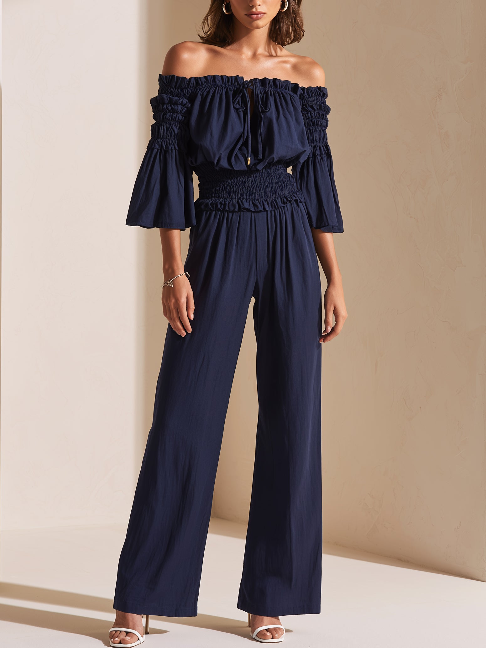 Elegant Dark Blue Off-shoulder Jumpsuit With A Drawstring Waist And Smocked Detailing.